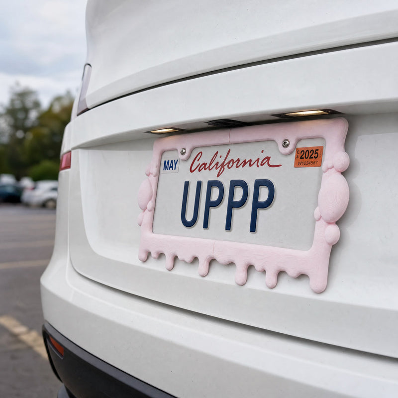 Pink slime license plate frame mounted on the rear of a white SUV in a parking lot