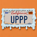 Baby blue slime drip license plate frame holding a California UPPP plate on an orange background