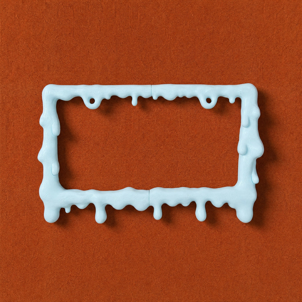 Empty baby blue drip license plate frame on a rust orange background