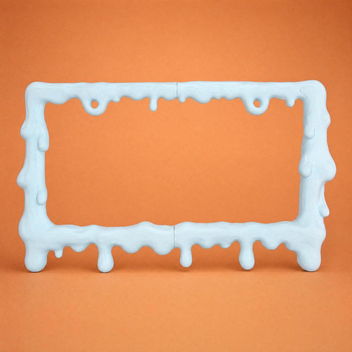 Baby blue slime license plate frame on a warm orange backdrop