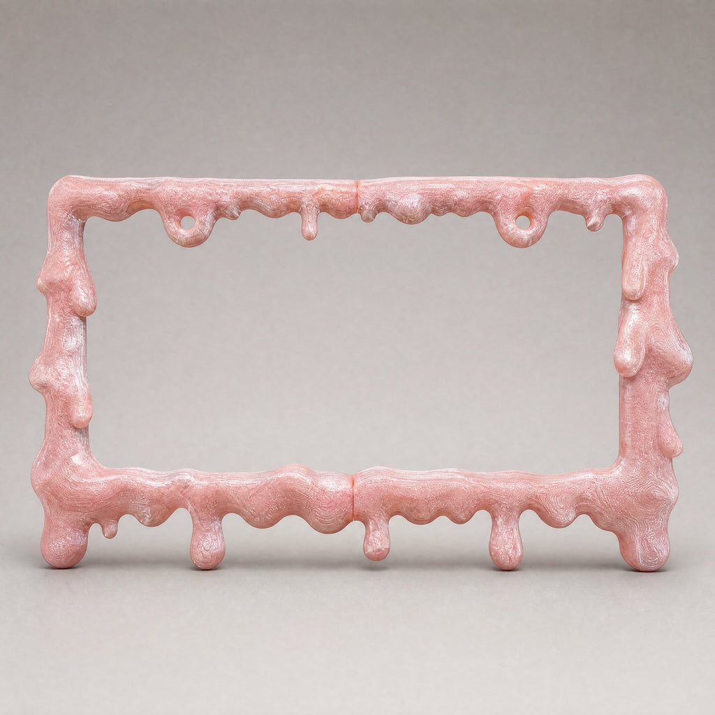 Crystal pink drip license plate frame on a soft grey backdrop
