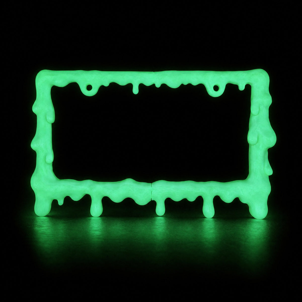 Glow in the dark slime license plate frame glowing green in a dark room