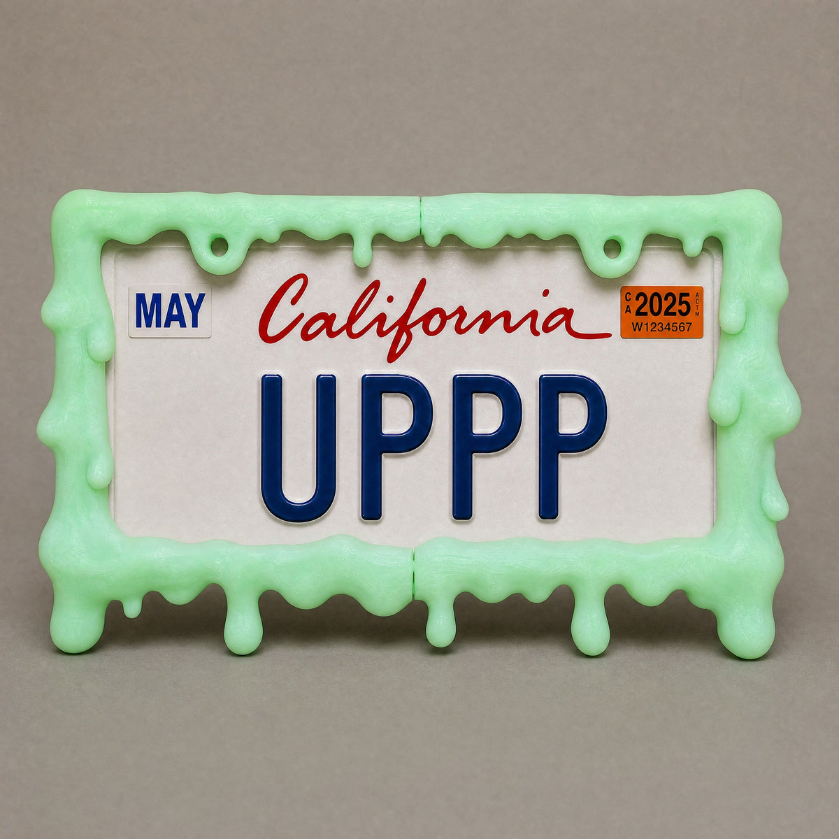 Glow green slime license plate frame held in a hand to show its size