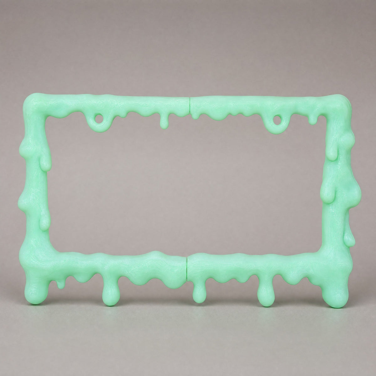 Glow green slime license plate frame at a three-quarter angle