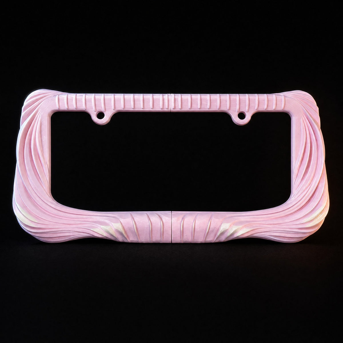 Blush pink Utopia license plate frame lit against a black background