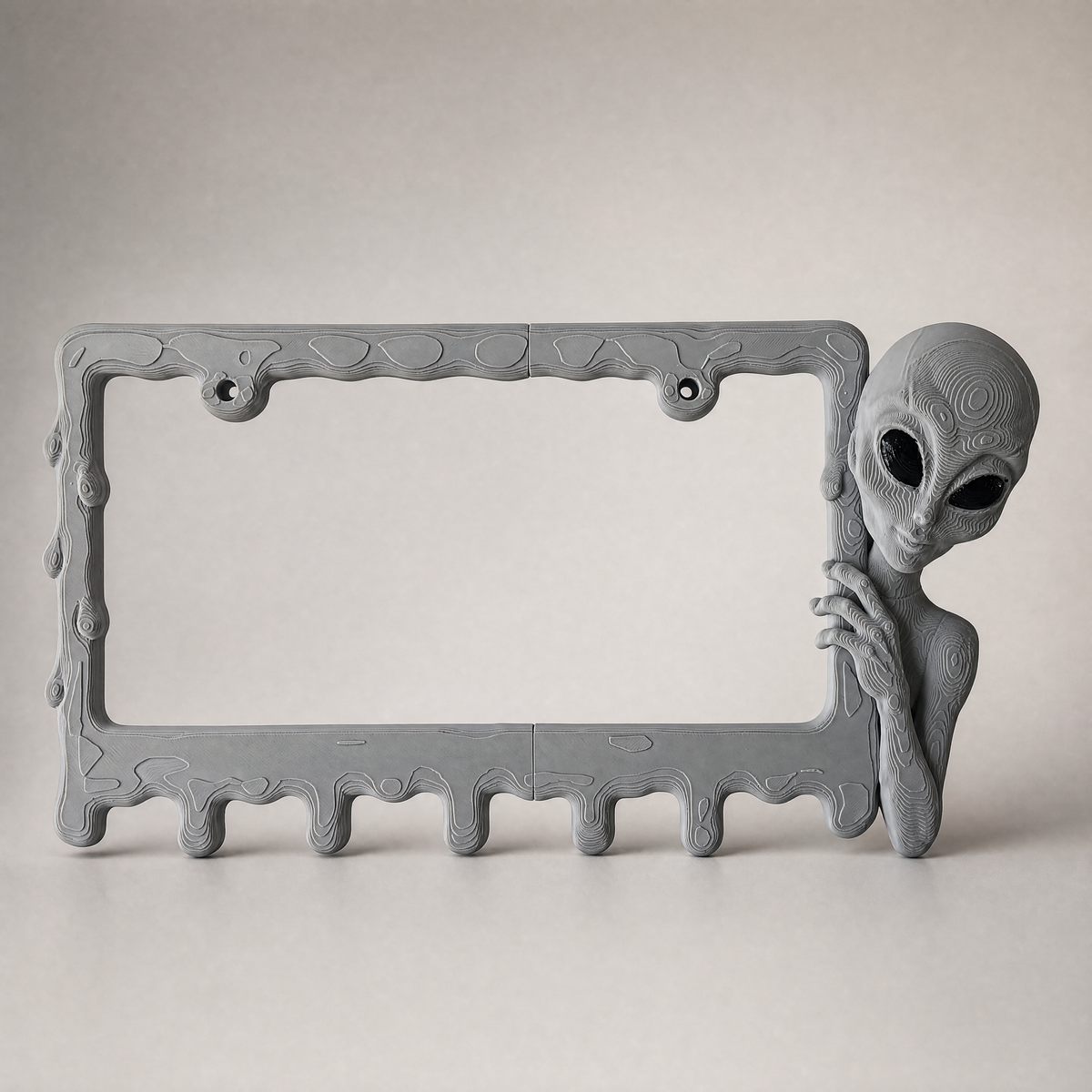 Graphite alien frame on a neutral grey studio backdrop